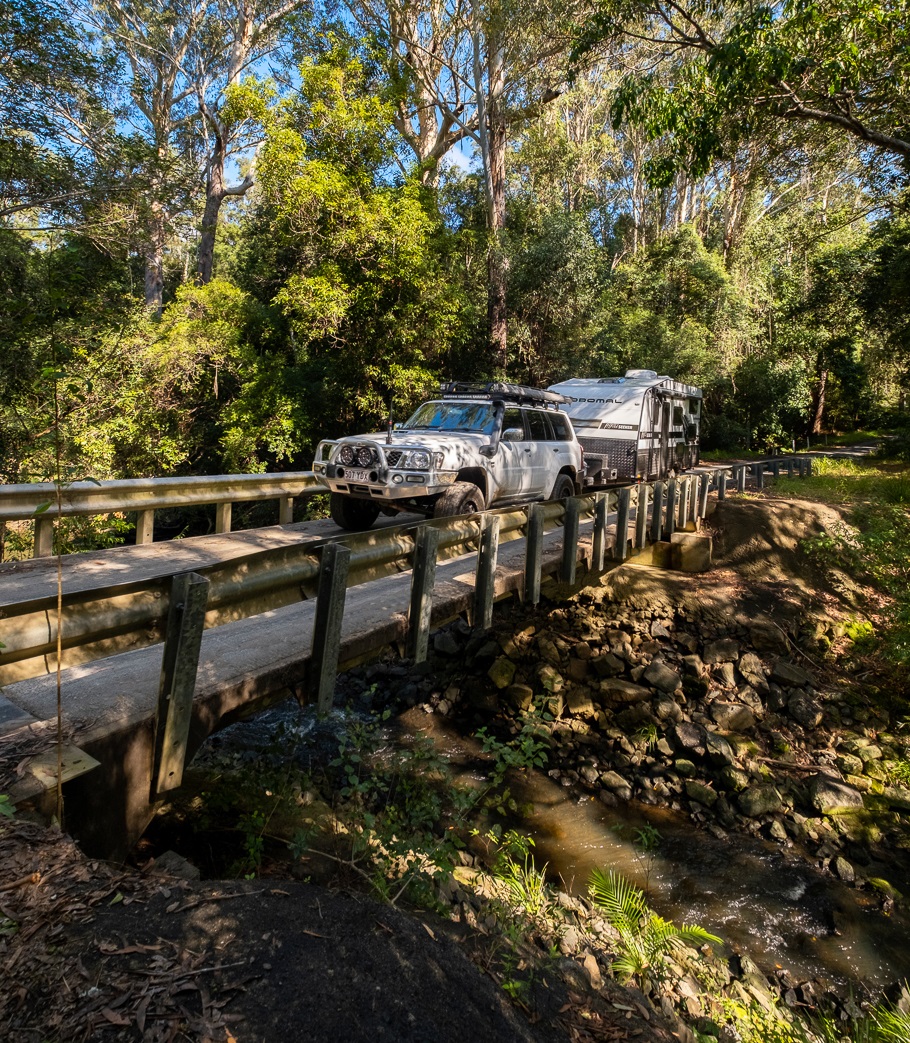 Thrill Seeker Caravan driving over bridge in rainforest